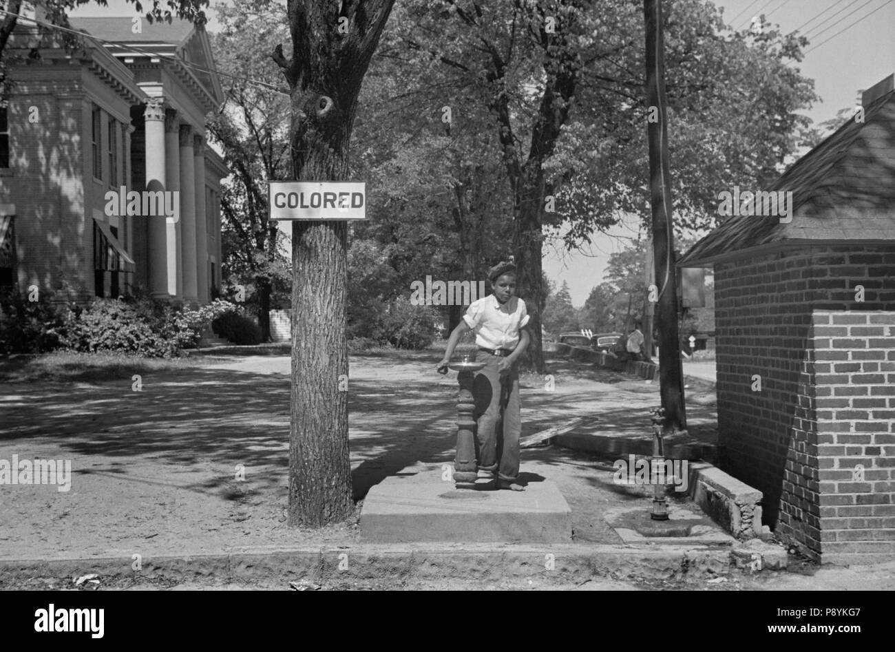 Boy at Drinking Fountain with Sign 'Colored' on County Courthouse Lawn, Halifax, North Carolina, USA, John Vachon, Farm Security Administration, April 1938 Stock Photo