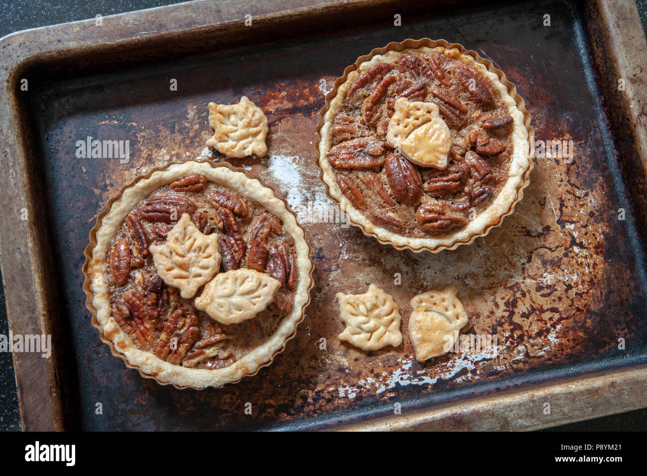 Two Mini Pecan Pies on Baking Sheet, High Angle View Stock Photo