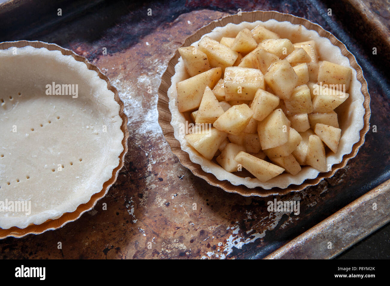 Mini Apple Pie on Baking Sheet, High Angle View Stock Photo
