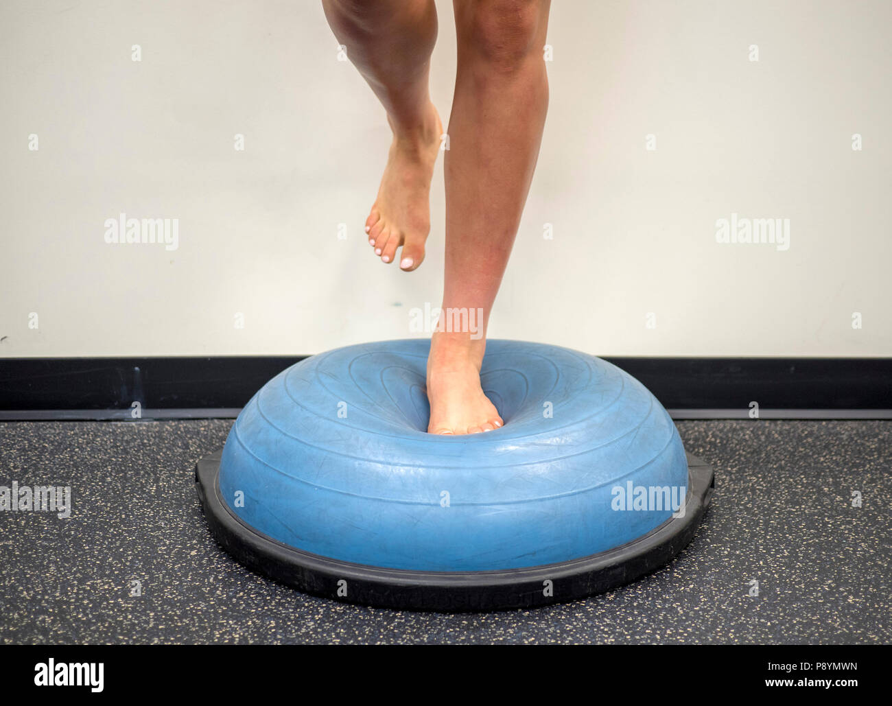 Single leg balance on a bosu ball for balance and strength training Stock Photo