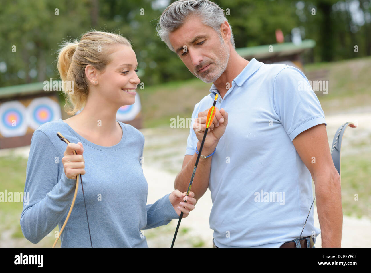Archers looking at tips of arrows Stock Photo