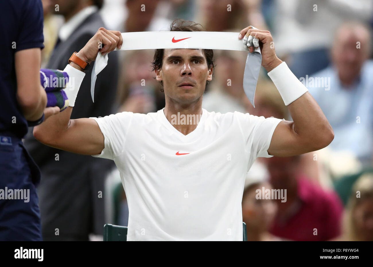 Rafael Nadal changes his head band during his match against Novak Djokovic on day eleven of the Wimbledon Championships at the All England Lawn Tennis and Croquet Club, Wimbledon. Stock Photo