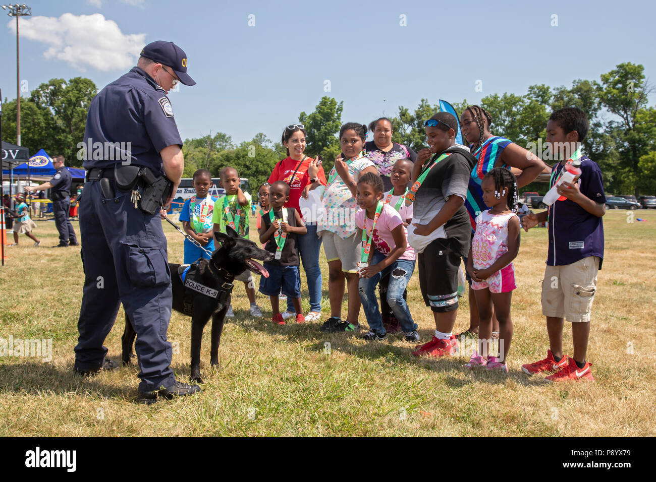 Detroit, Michigan - A U.S. Customs and Border Protection officer shows his dog, Buddy, to children at Metro Detroit Youth Day. Buddy is trained to det Stock Photo