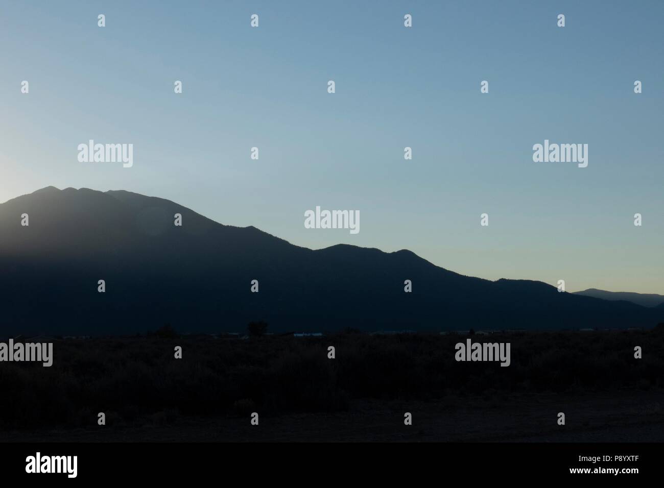 Sunrise over Taos Mountain in the Sangre de Cristo mountain range in Taos New Mexico Stock Photo
