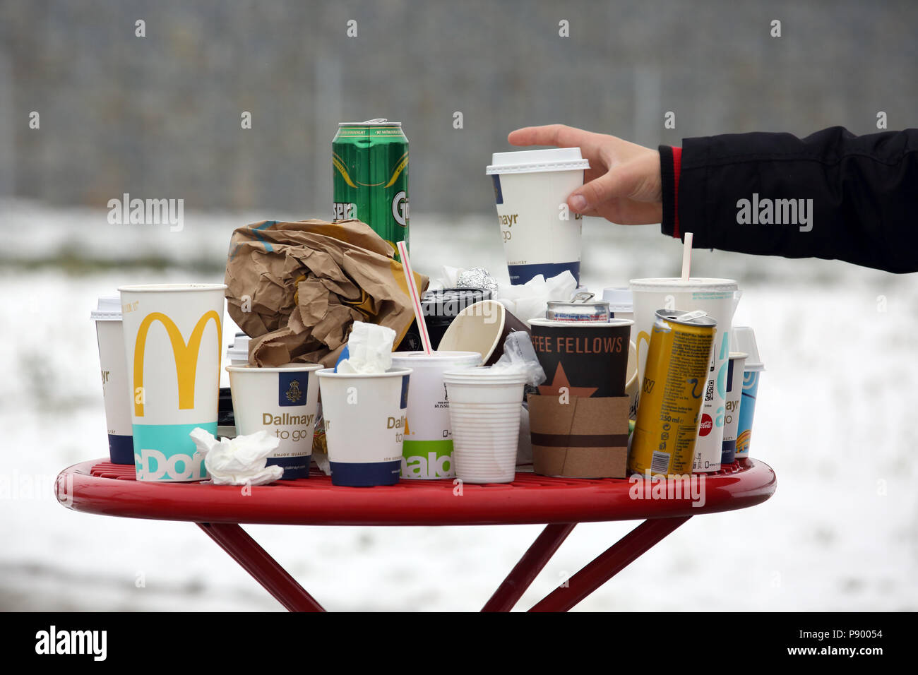 Hermsdorf, Germany, Empty coffee mugs, beverage cans and crumpled paper ducks on a rest area table Stock Photo