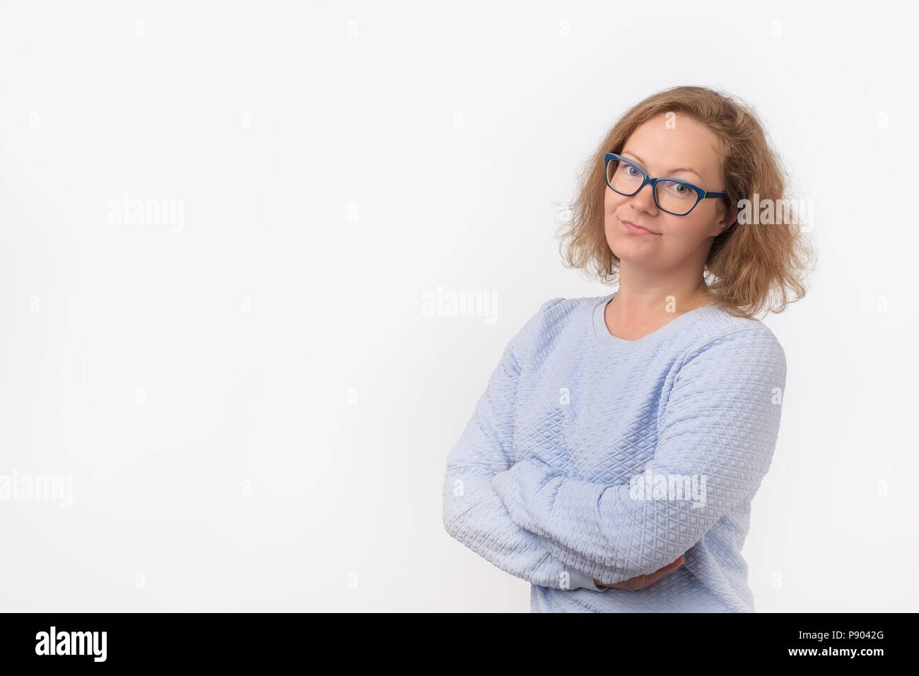 Closeup portrait of skeptical young caucasian woman in blue shirt, woman looking suspicious, some disgust on her face. Stock Photo