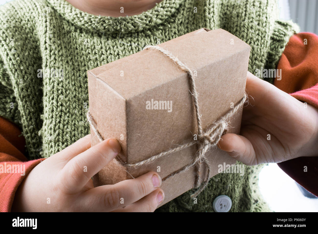 Baby holding a wrapped gift box on white background Stock Photo - Alamy