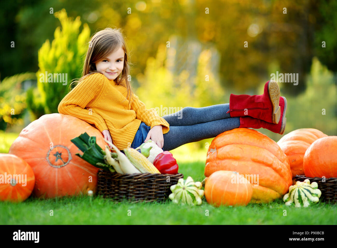 Adorable little girl having fun on a pumpkin patch on beautiful autumn ...