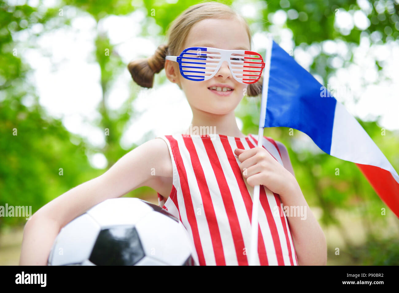 Adorable little soccer fan cheering on summer day Stock Photo