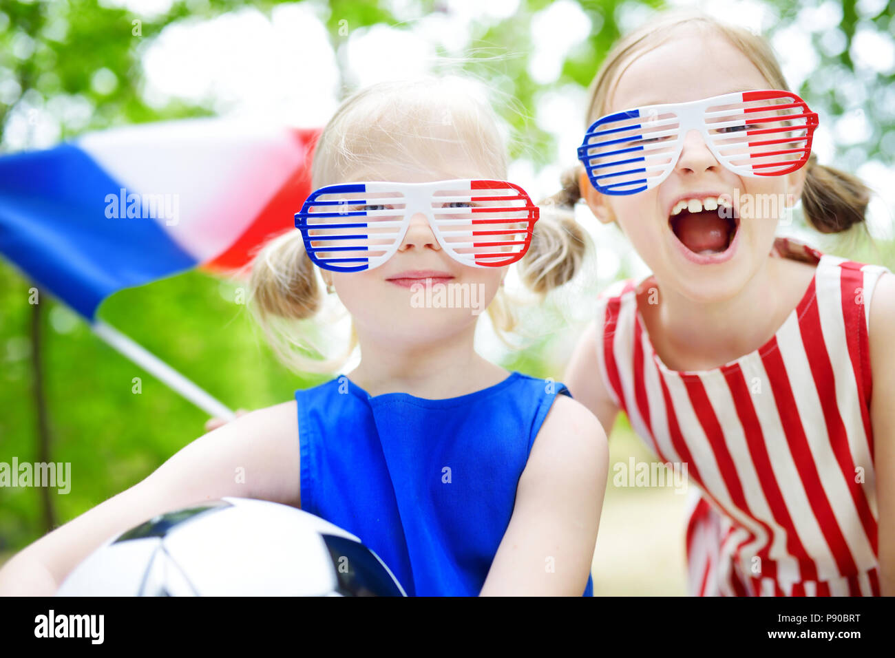 Two adorable little soccer fans cheering on summer day Stock Photo