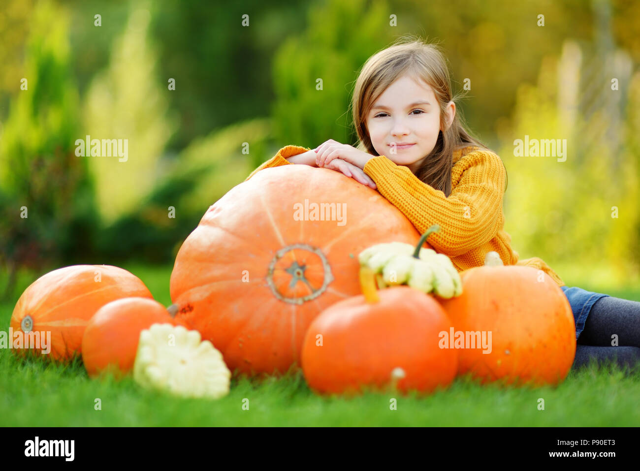 Adorable little girl having fun on a pumpkin patch on beautiful autumn ...