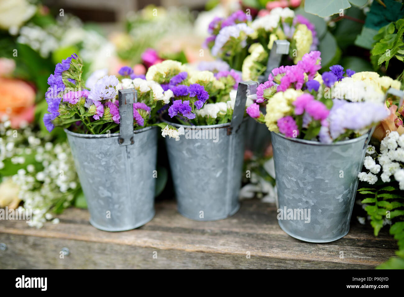 Three buckets of beautiful purple and white flowers prepared for wedding ceremony or another festive event Stock Photo