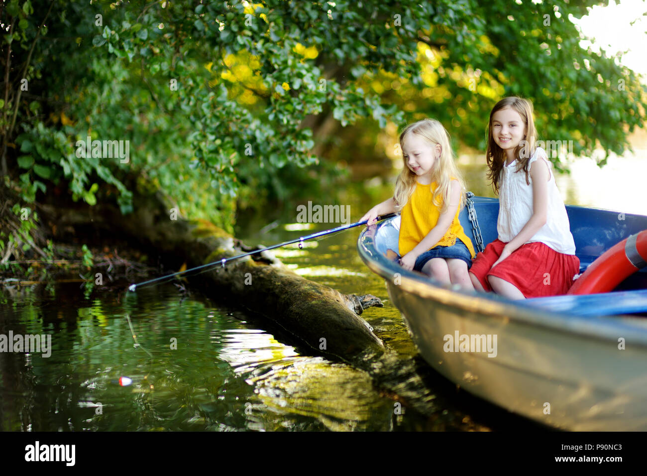 Two young girls standing on jetty, fishing using fishing rods, Stock Photo,  Picture And Royalty Free Image. Pic. ISO-IS09B8K5F