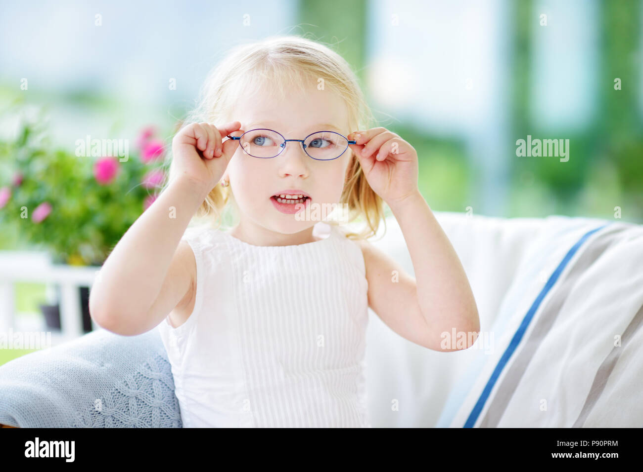 Portrait of beautiful little girl wearing glasses at home. Vision, health, ophthalmology concept