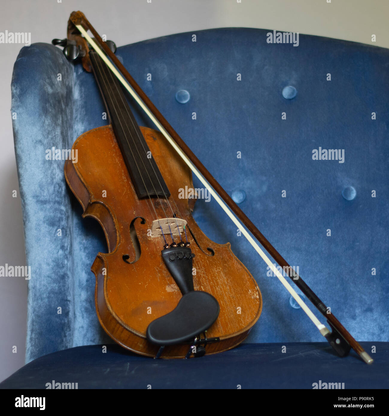 Vintage Violin and Bow Resting on Blue Button Tufted Chair Stock Photo Alamy