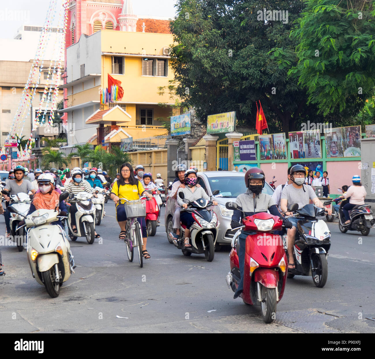 A lone female cycling riding her bike in traffic full of motorbikes