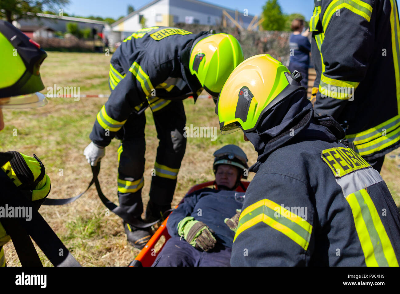 DELMENHORST / GERMANY - MAY 6, 2018: German firefighters  train a patient transport on a meadow. Feuerwehr means german fire department. Stock Photo