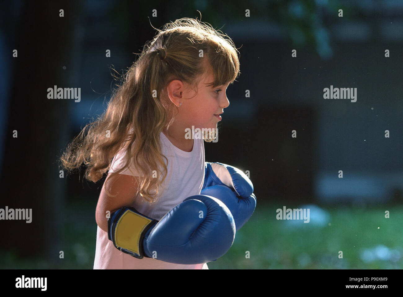 Little girl wearing blue boxing gloves Stock Photo Alamy