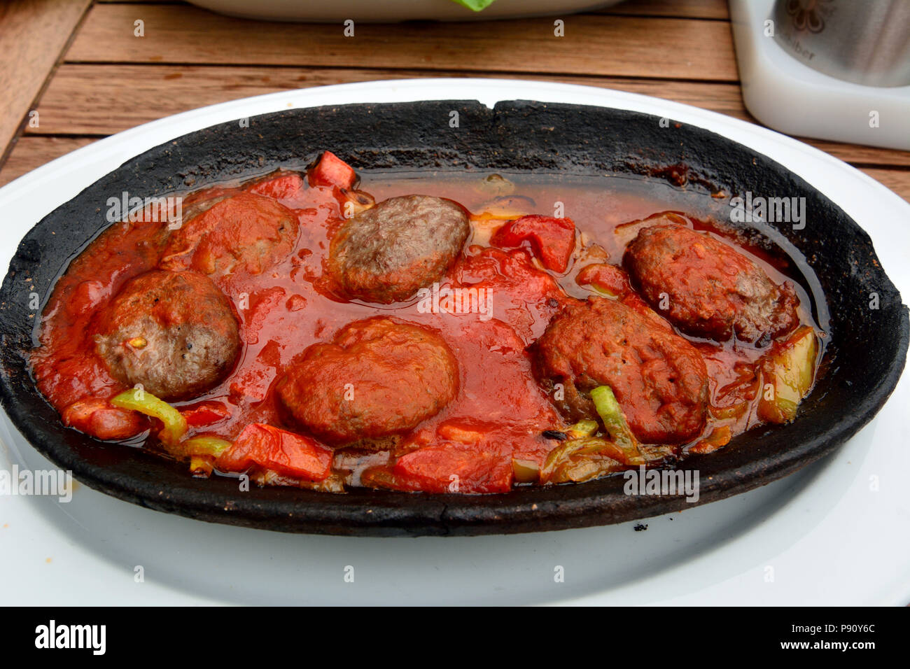 Plate of Turkish kofte with tomato sauce. Stock Photo
