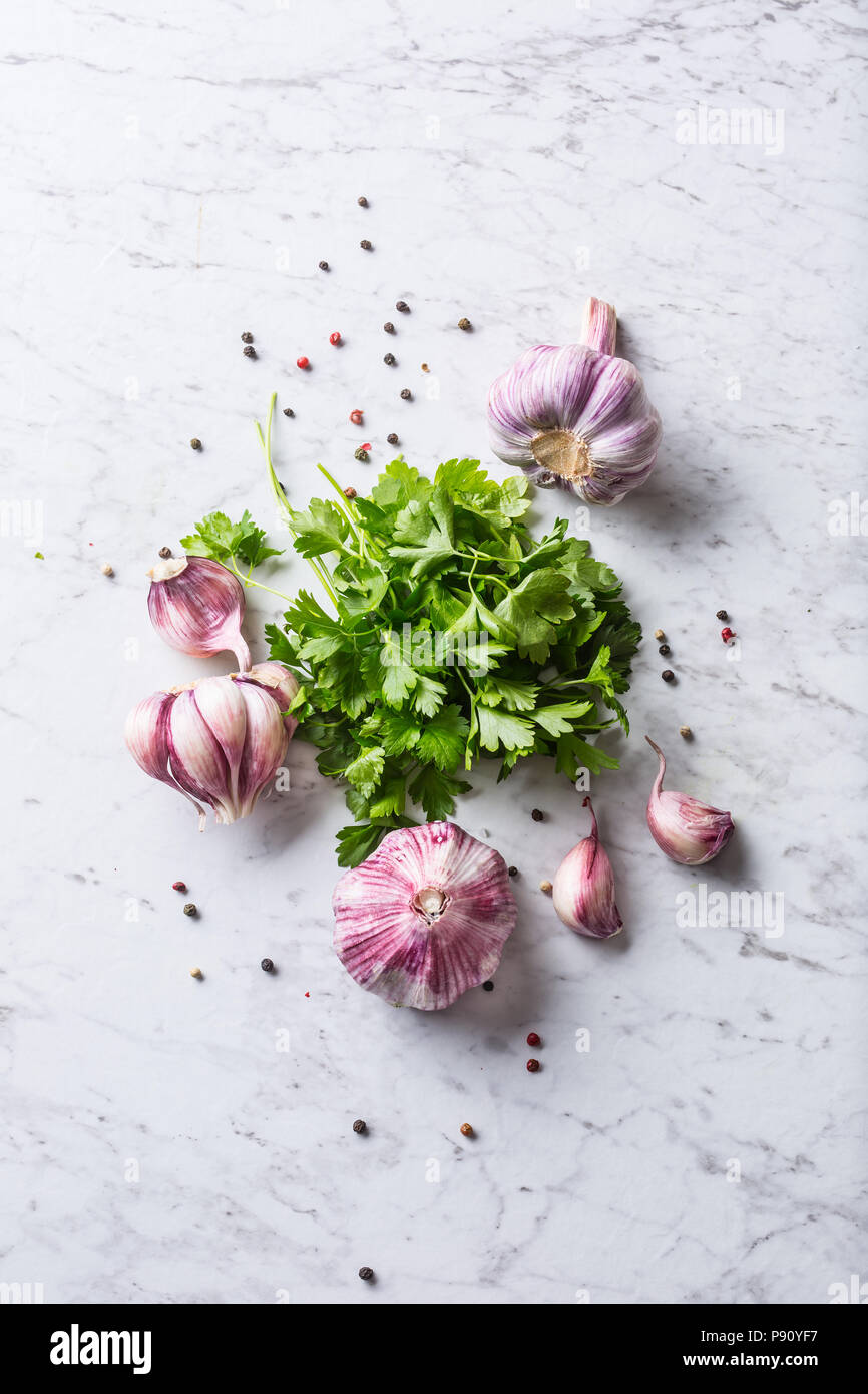 Garlic Cloves and Bulbs with parsley herbs salt and pepper Stock Photo
