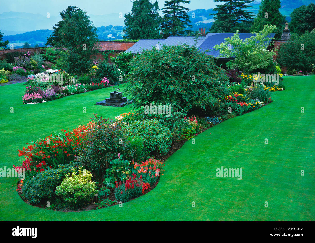Aerial view of colourful flower island beds in lawn of a country house