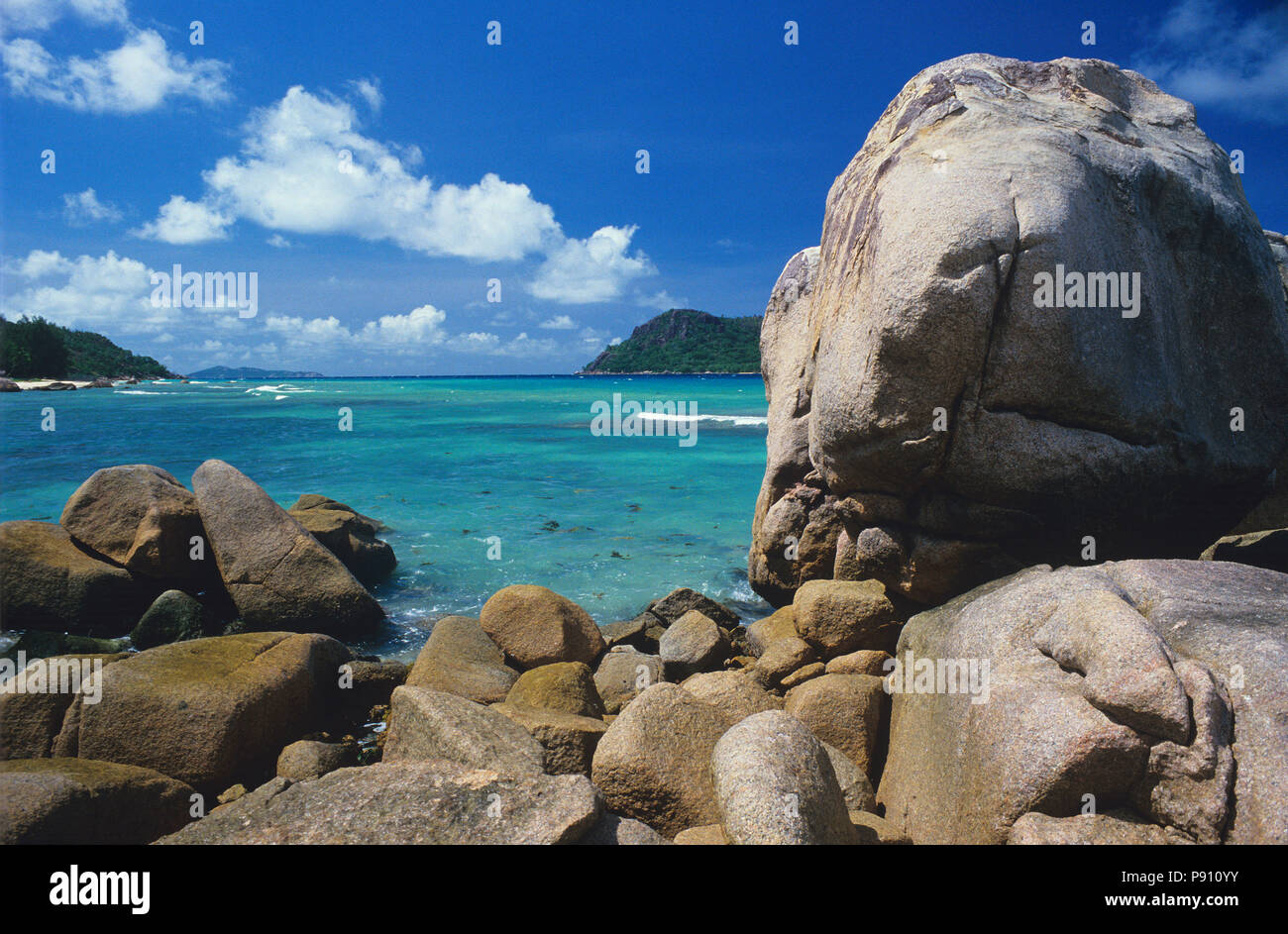 BEACH WITH LARGE ROCK AND ISLAND VIEW, SEYCHELLES, ISLAND, EAST AFRICA. JUNE 2009. The beautiful islands of the Seychelles in the Indian Ocean offer p Stock Photo