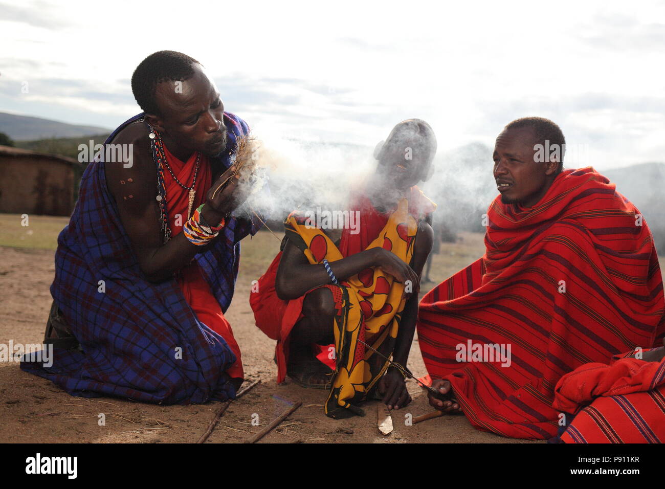 Maasai traditional man setting up fire in a traditional way, smoke and fire tribal Stock Photo