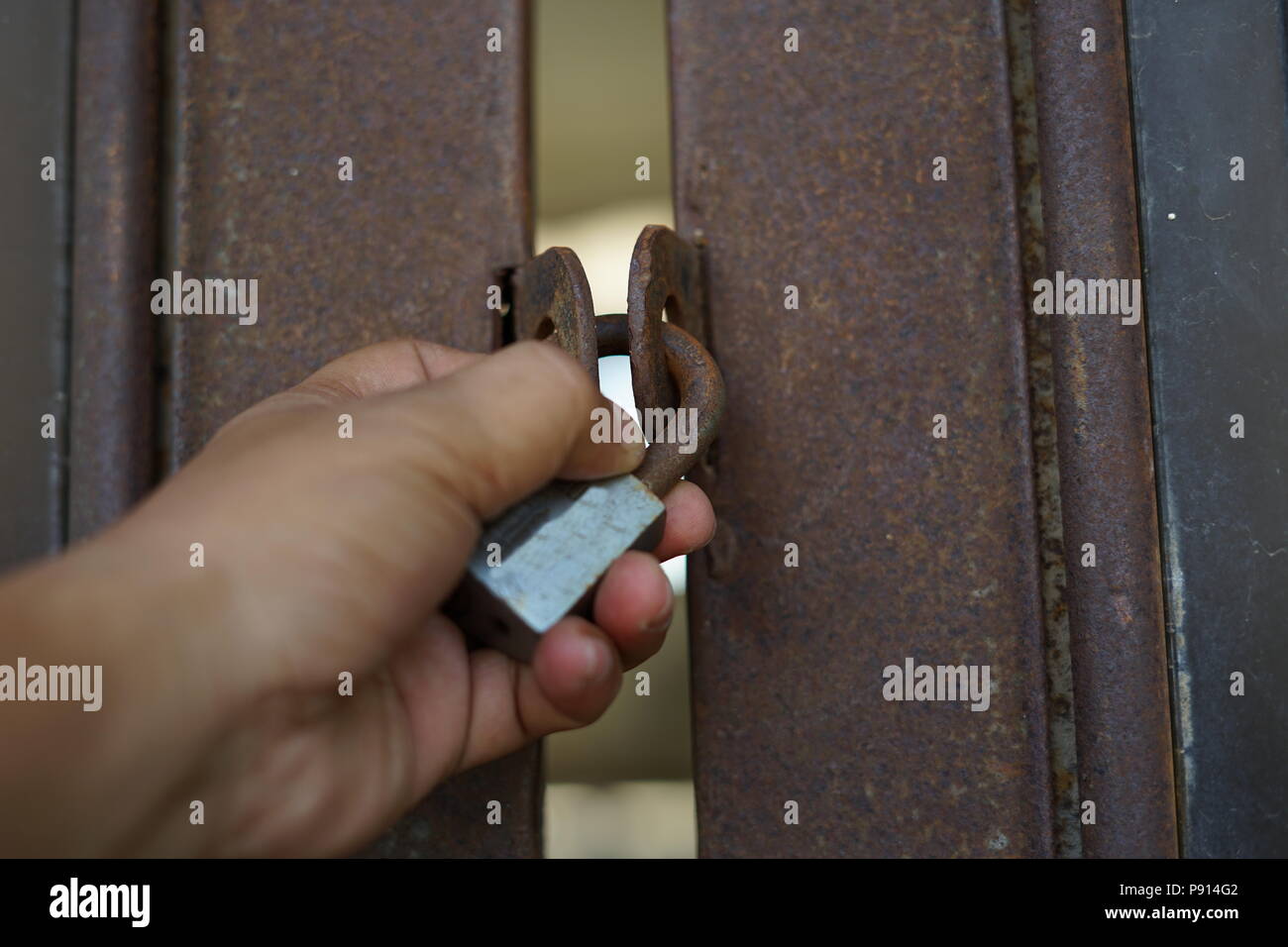 Old rusty padlock on Gate. Property protection Stock Photo