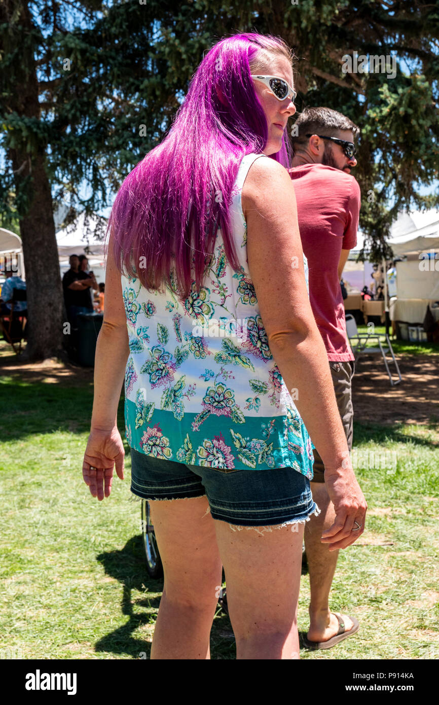 Woman with long purple hair walking in park; Salida; Colorado; USA Stock Photo