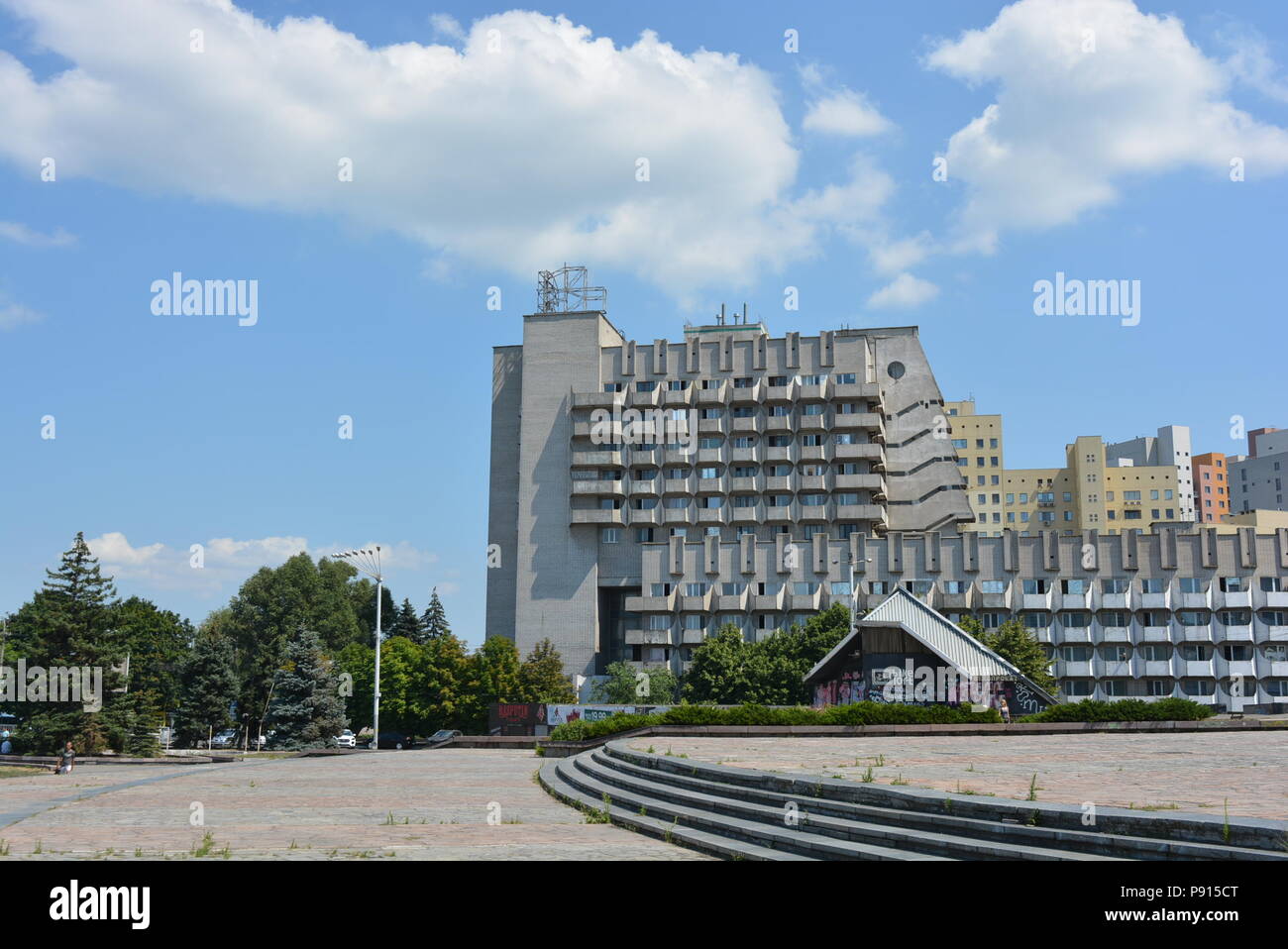 Urban hotel facilities with a gentle blue sky and soft and airy clouds and trees. Stock Photo
