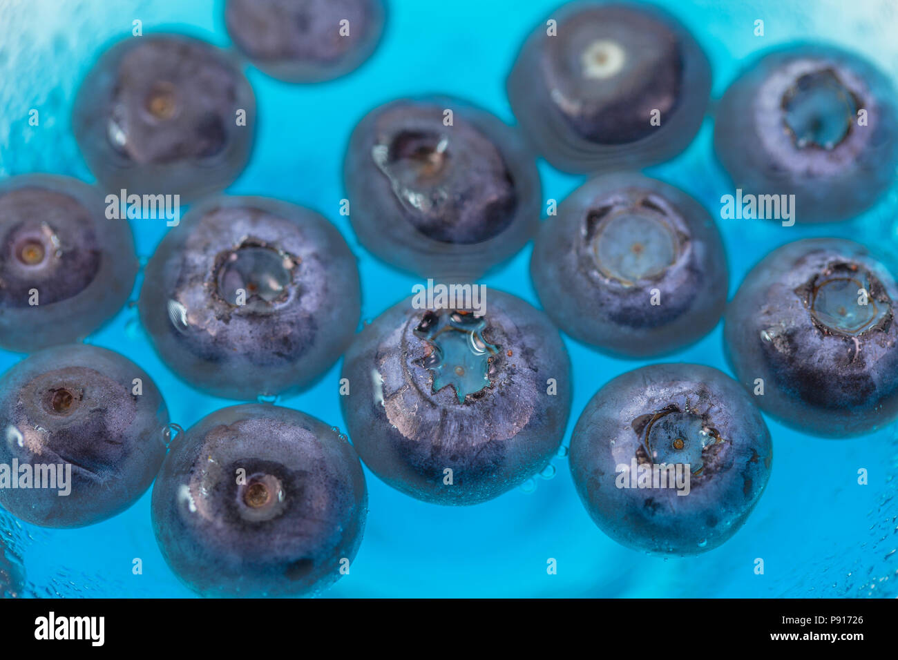blueberry floating in a cup of blue water Stock Photo Alamy
