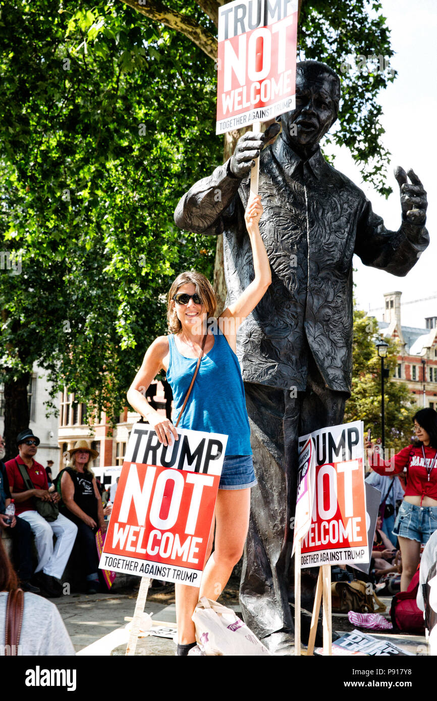 London, England, UK. 13th July, 2018. A woman seen standing by a statue of Nelson Mandela surrounded by Trump not welcome signs.Protest by anti-Trump supporters against Donald Trump's visit to the United Kingdom that took place in central London. Credit: Joel Fowler/SOPA Images/ZUMA Wire/Alamy Live News Stock Photo