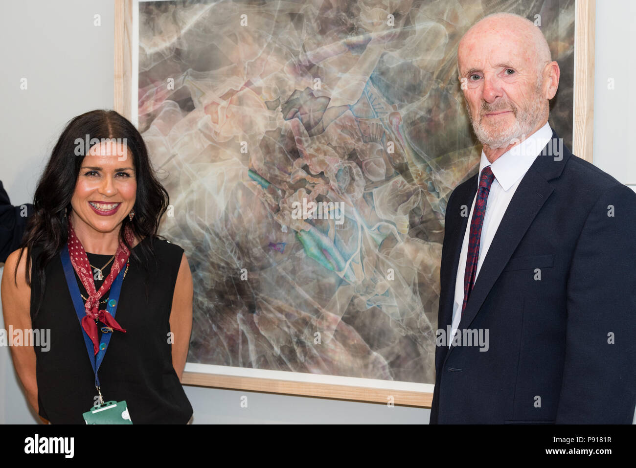 Oriel Môn, Llangefni, Gwynedd, Wales, UK. Friday 13 July 2018. The Opening night and prize awards for the centenary and fourth Kyffin Williams Drawing Prize exhibition, sponsored by ITV Cymru Wales and Rogers Jones auctioneers, was held at Oriel Môn, with Nicola Gibson (L) receiving the Student Prize for the ' Plan for a Bath House' on behalf of George Bolwell, from David Rogers Jones (L) . Credit: Michael Gibson/Alamy Live News Stock Photo