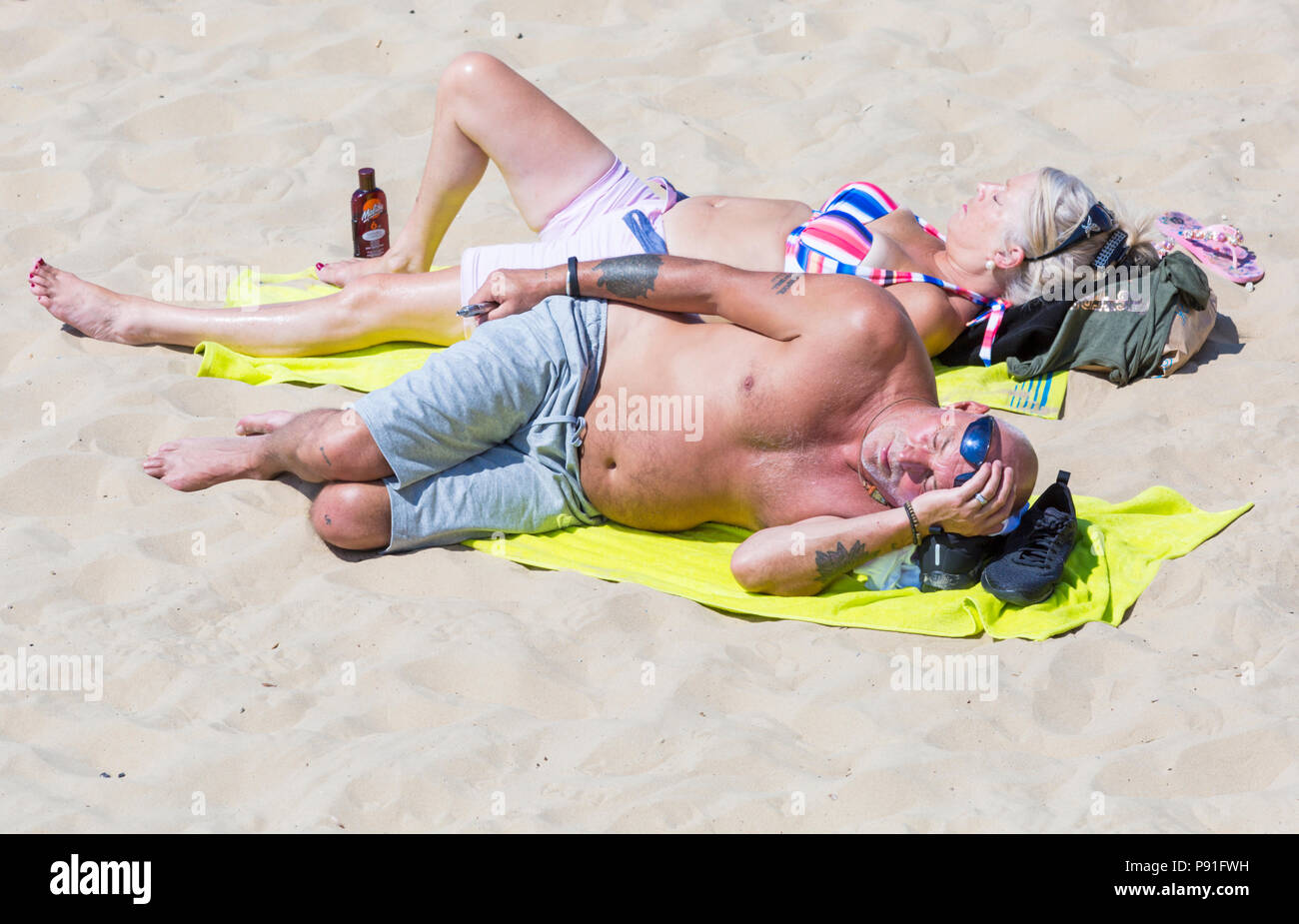 Bournemouth, Dorset, UK. 14th July 2018. UK weather: The heatwave continues with another hot sunny day, as sunseekers make the most of the glorious weather and head to the seaside at Bournemouth beaches. Couple sunbathing on beach. Credit: Carolyn Jenkins/Alamy Live News Stock Photo