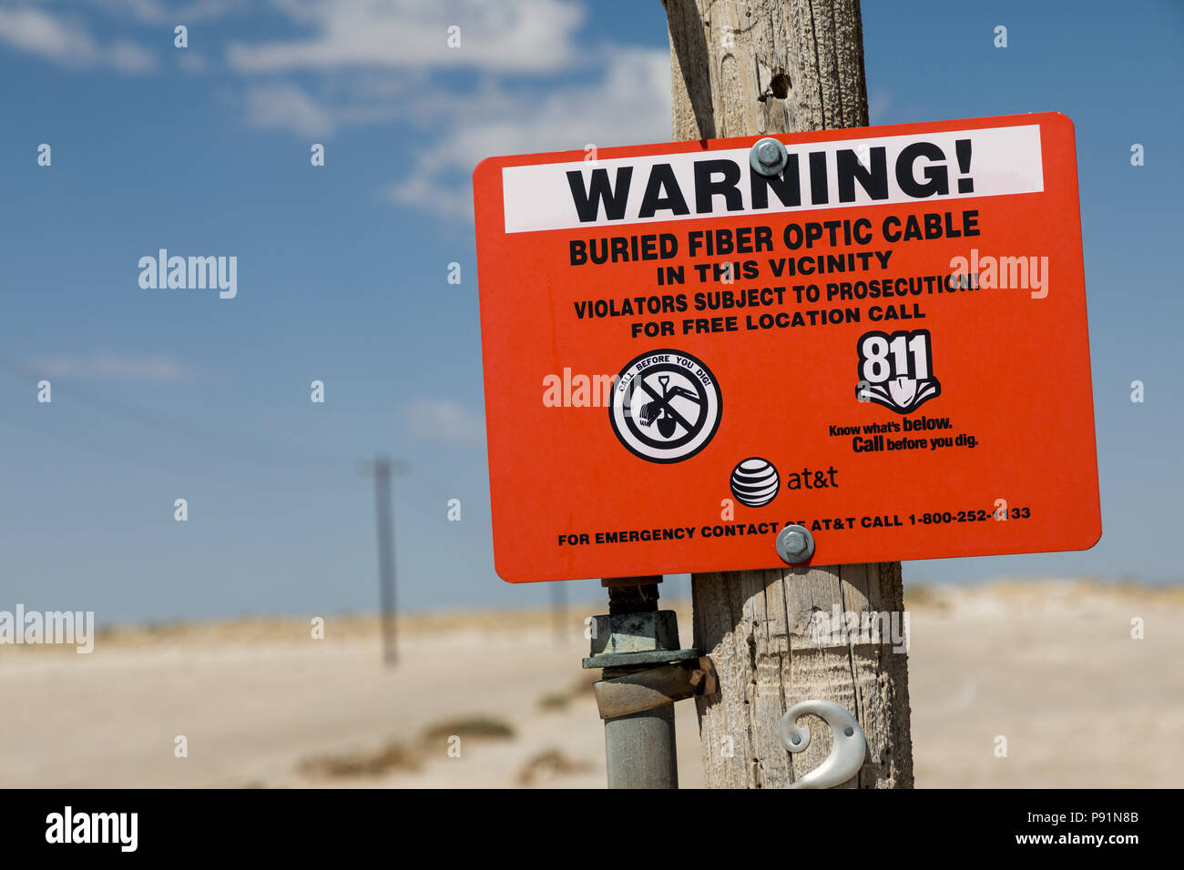 Warning sign for buried fiber optic cable in desert, New Mexico, USA Stock Photo