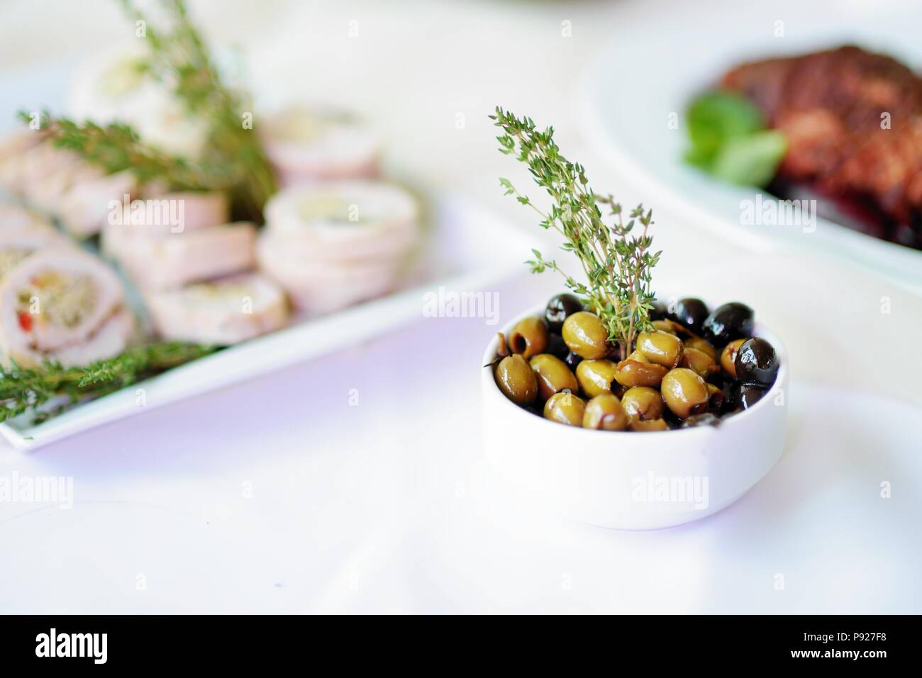 Delicious olives served on a party or wedding reception. Plates with  assorted fancy finger food snacks on an event party or dinner Stock Photo -  Alamy, image size:1300x956