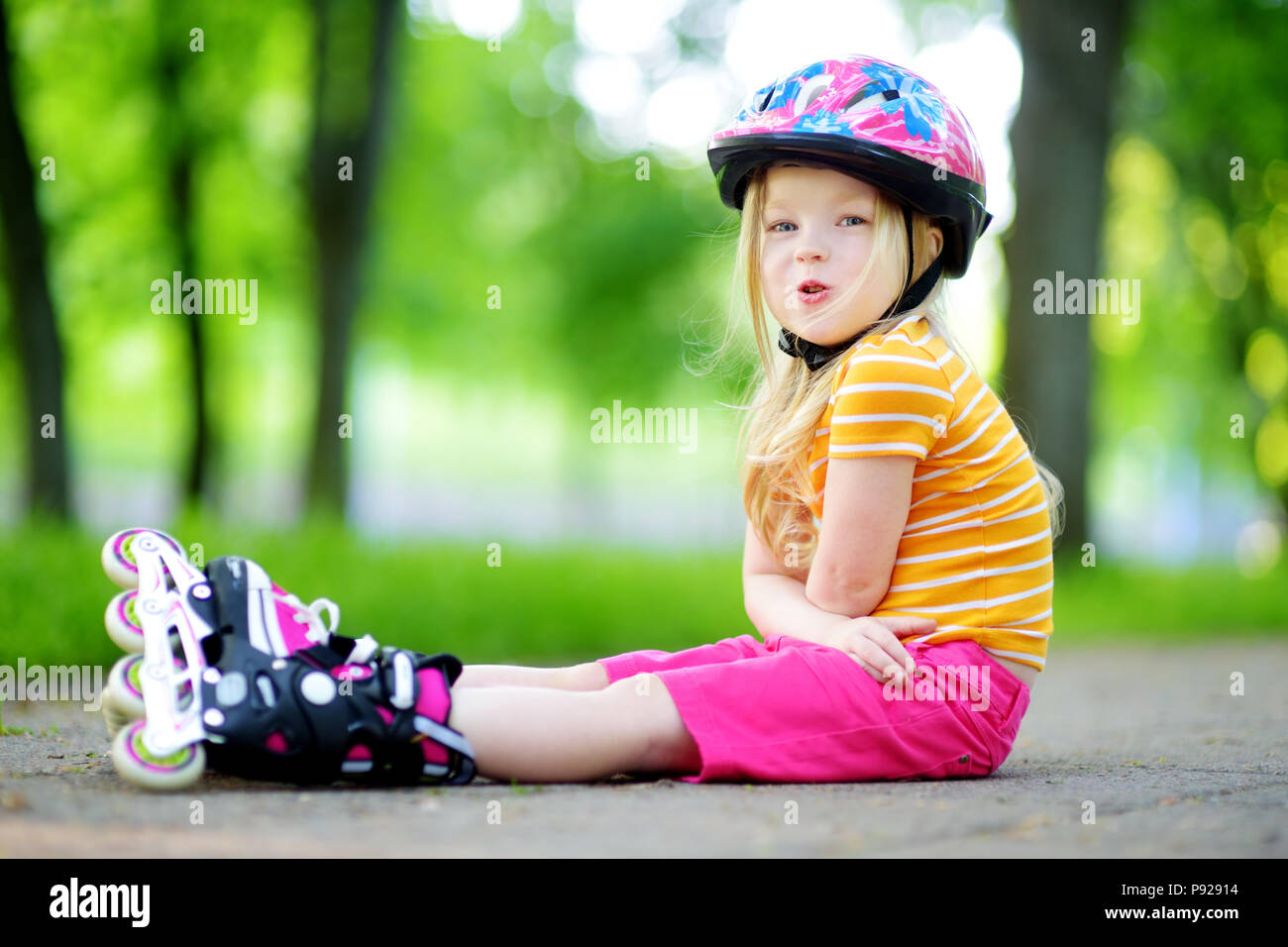 Girl and boy learn to roller skate in summer park. Children wearing  protection pads and safety helmet for safe skating Stock Photo - Alamy