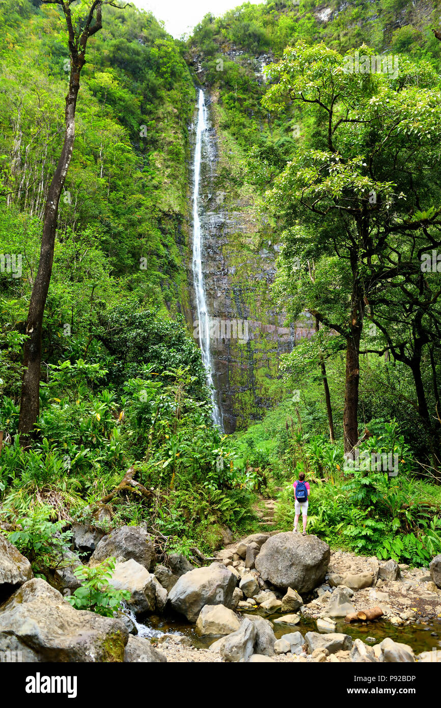 Young female tourist hiking to the famous Waimoku Falls at the head of