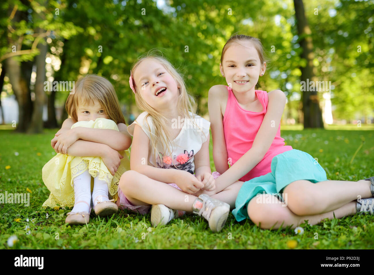Three cute little sisters having fun together on the grass on a sunny summer day. Funny kids hanging together outdoors. Active family leisure Stock Photo - Alamy Three cute little sisters having fun together on the grass on a sunny summer day. Funny kids hanging together outdoors. Active family leisure Stock Photo - Alamy