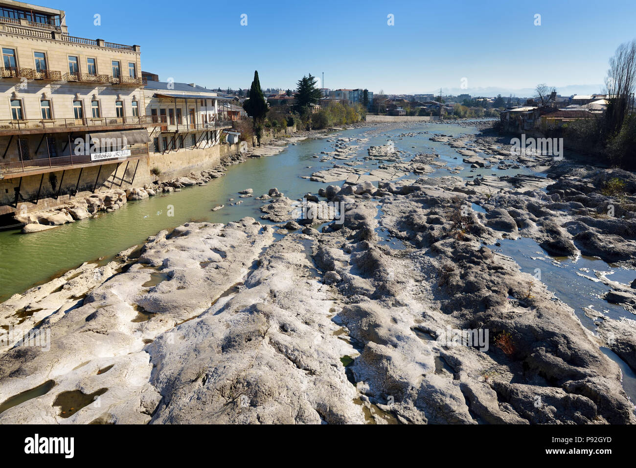 KUTAISI, GEORGIA - NOVEMBER 22, 2016: Majestic Rioni river flowing through Kutaisi town in Georgia. View from famous White Brigde, a bicycle and pedes Stock Photo