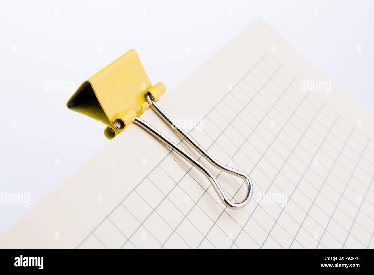 Colored paper clip on a checked notebook  page Stock Photo