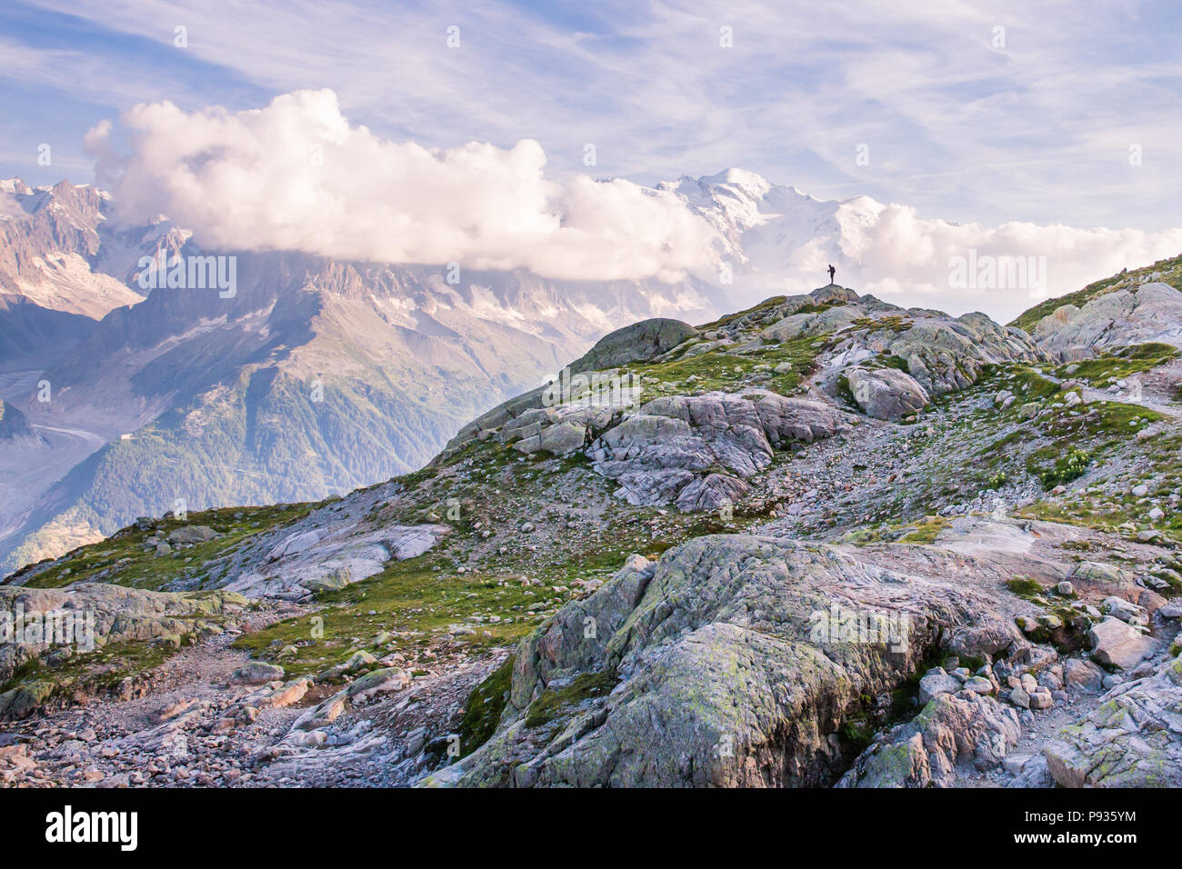 Outdoor Photographer Standing on the Edge of Mountain in front of Iconic Mont-Blanc Stock Photo