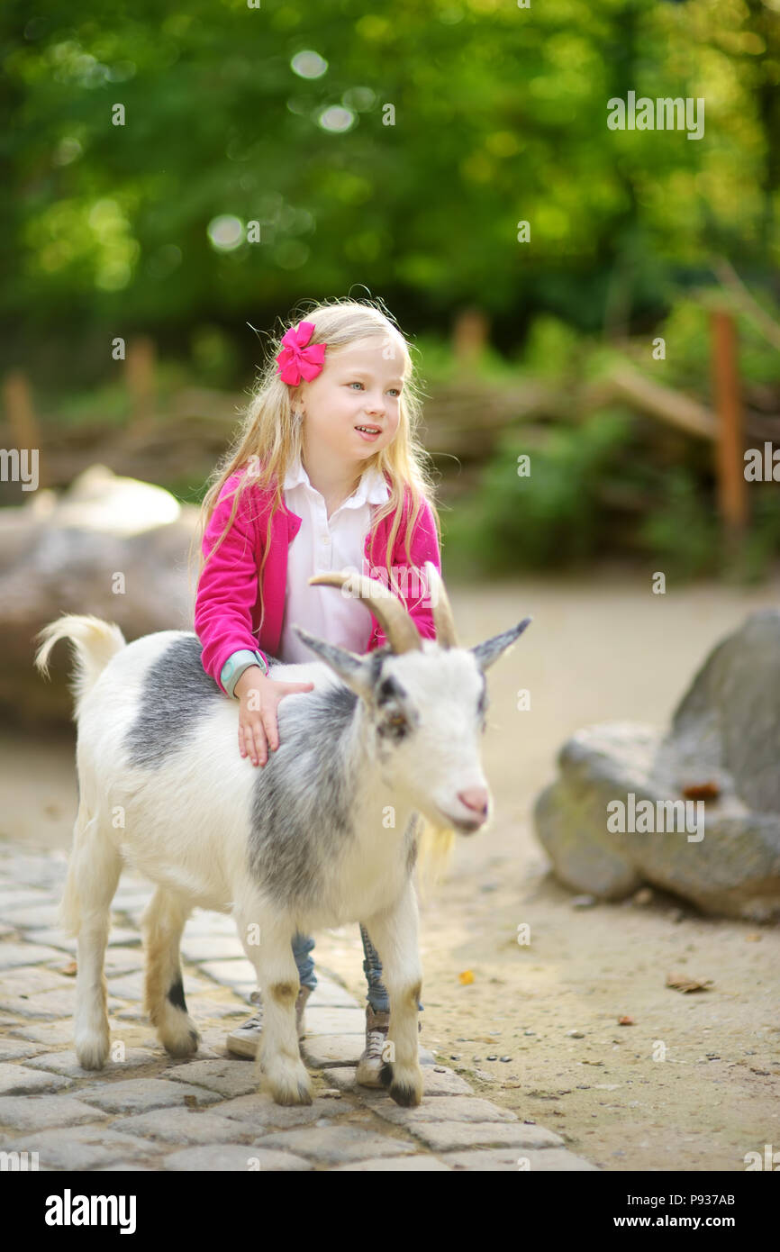 Cute little girl petting and feeding a goat at petting zoo. Child playing with a farm animal on sunny summer day. Kids interacting with animals Stock Photo - Alamy Cute little girl petting and feeding a goat at petting zoo. Child playing with a farm animal on sunny summer day. Kids interacting with animals Stock Photo - Alamy