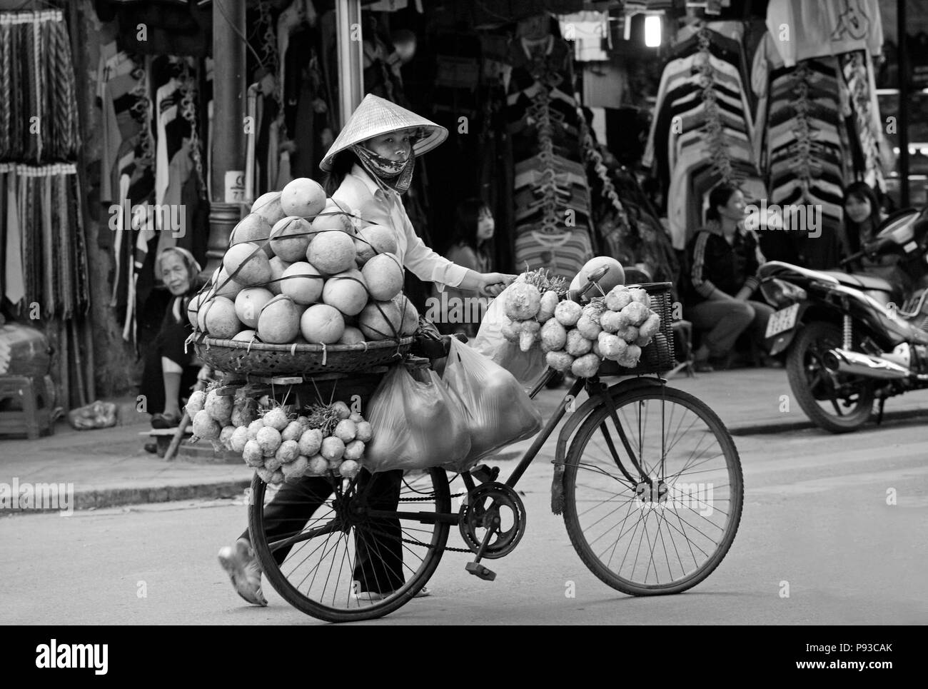 A mobile fruit and vegetable merchant transports his product via bicycle - HANOI, VIETNAM Stock Photo