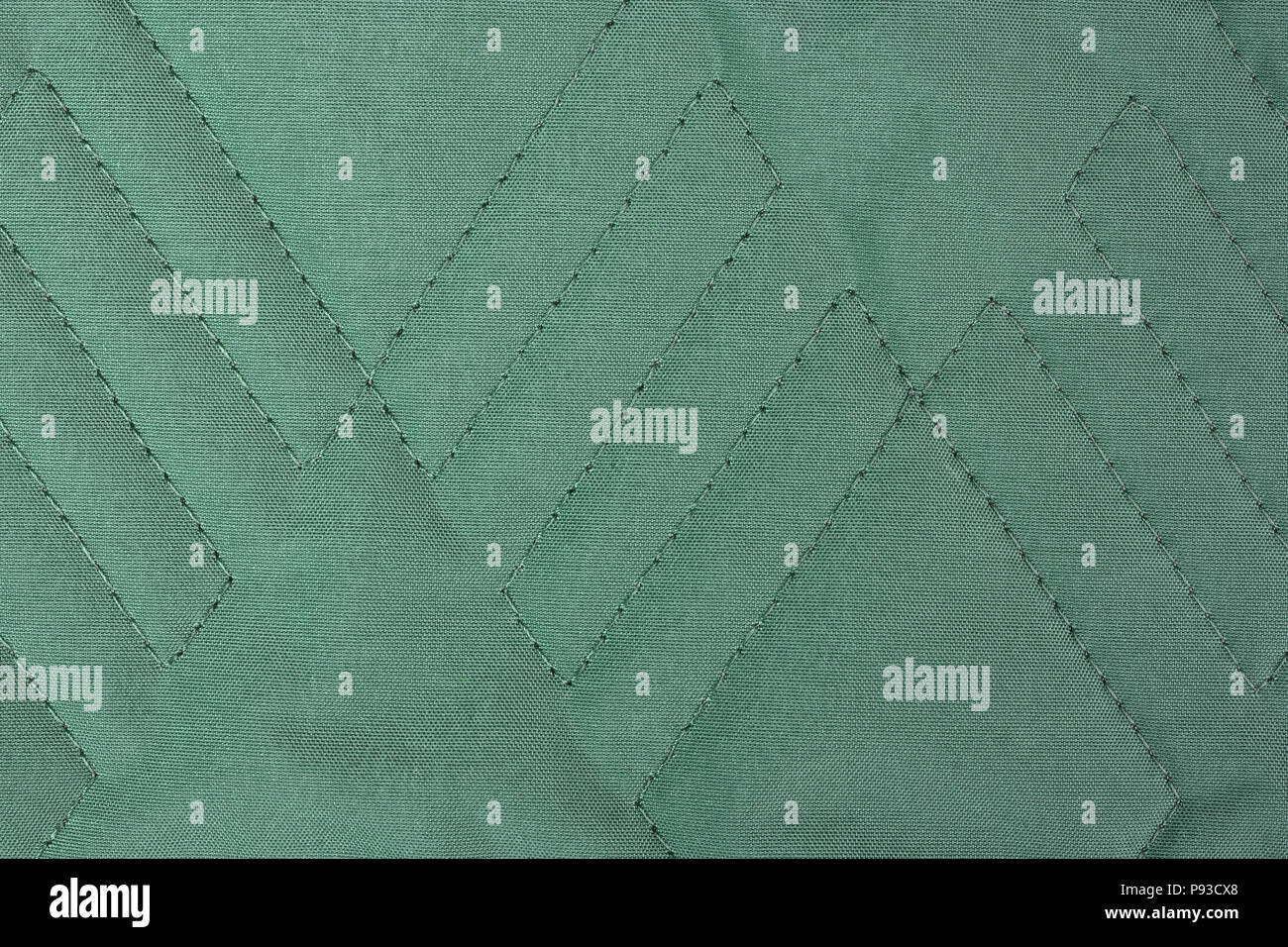 Green quilted fabric texture with geometric pattern Stock Photo