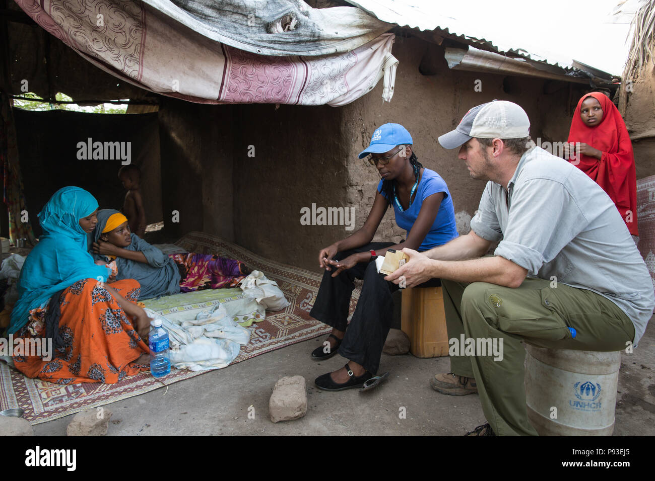 Kakuma, Kenya - Kai Feldhaus, reporter and journalist of the Bild newspaper in conversation with a refugee family in the Kakuma refugee camp. Stock Photo