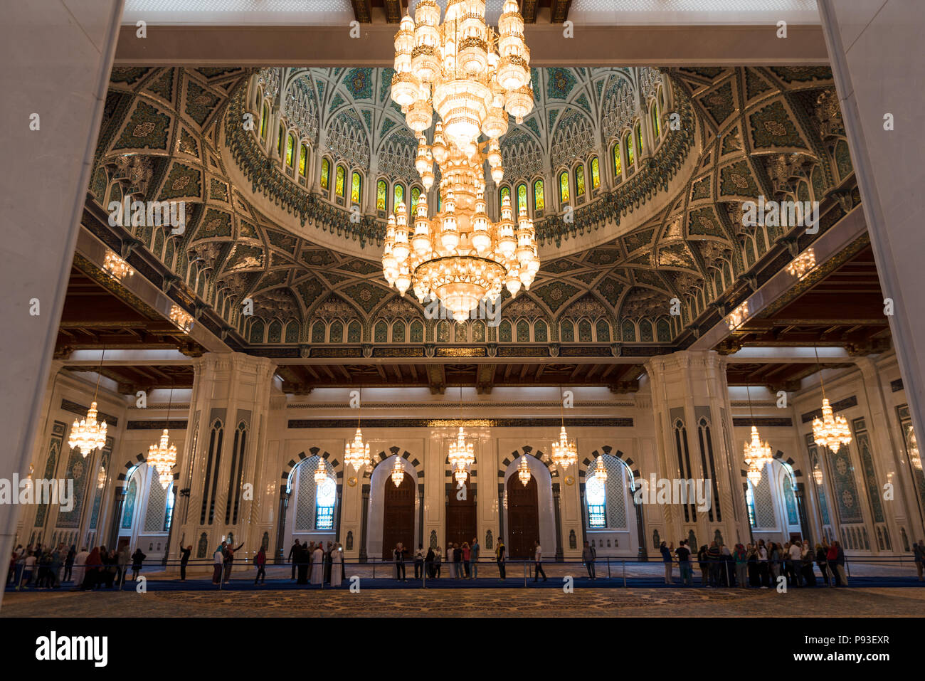 Main prayer hall of Sultan Qaboos Grand Mosque in Muscat, Oman.  Visitors to the mosque are clearly visible Stock Photo