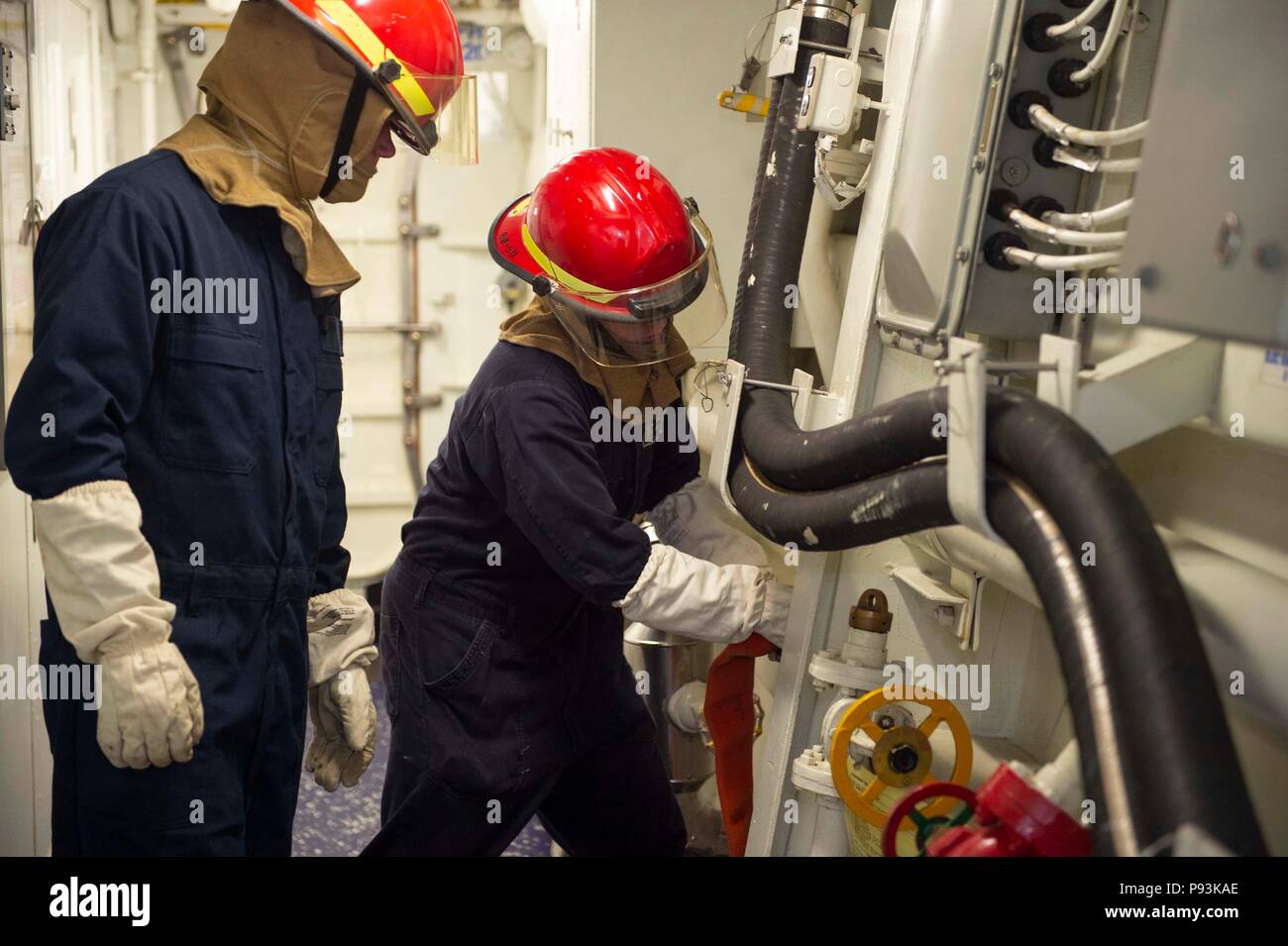 180706-N-JO245-063 ATLANTIC OCEAN (July 6, 2018) Damage Controlman 2nd Richard Barker, left, observes as Yeoman 3rd Class Seth Wyatt connects a hose to a overboard discharge valve during a general quarters drill aboard the guided-missile destroyer USS Forrest Sherman (DDG 98). Forrest Sherman is underway for a scheduled deployment as part of the Harry S. Truman Carrier Strike Group. With Harry S. Truman as the flagship, deploying strike group assets include staffs, ships and aircraft of Carrier Strike Group (CSG) 8, Destroyer Squadron (DESRON) 28 and Carrier Air Wing (CVW) 1; as well as the Sa Stock Photo