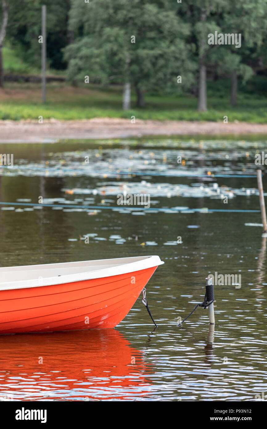 Abstract conceptual selective focus view of bow of moored rowing boat tied up and anchored on a tranquil lake Stock Photo