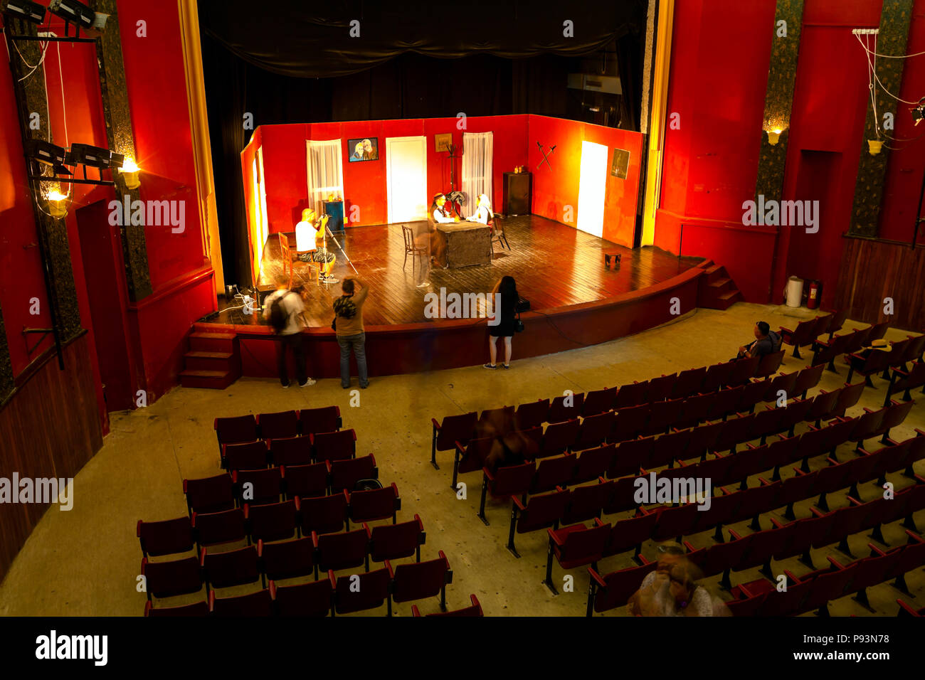 Long exposure photo, photographers are taking photo together of young woman posing in empty theater stage. Stock Photo